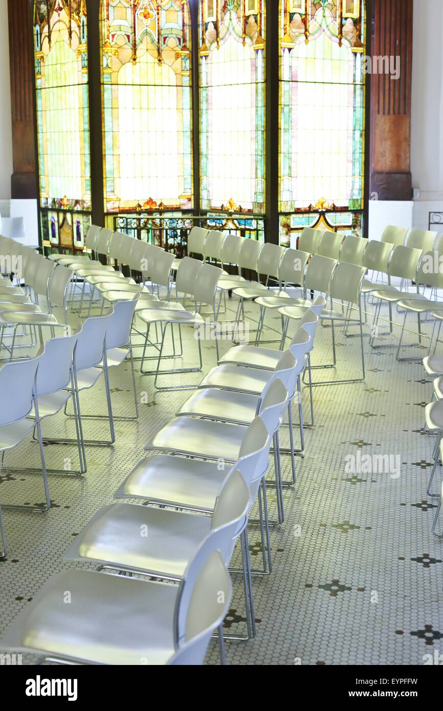 Ein Raum voller Zeilen der leere weiße Plastikstühle. Stockfoto