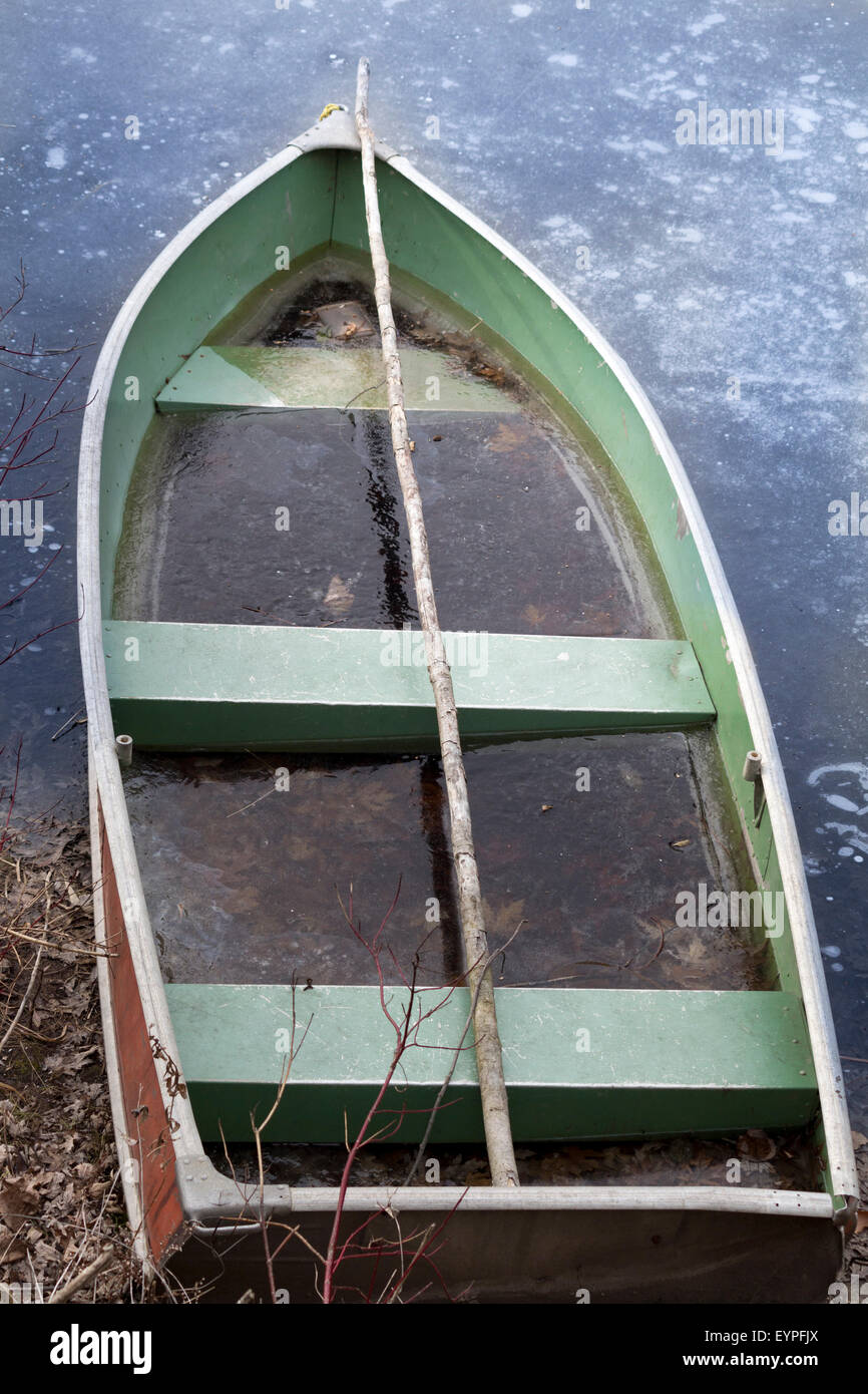 Verlassene Schiff gefüllt mit schmutzigem Wasser sitzen am Ufer zum Teil im Wasser Stockfoto