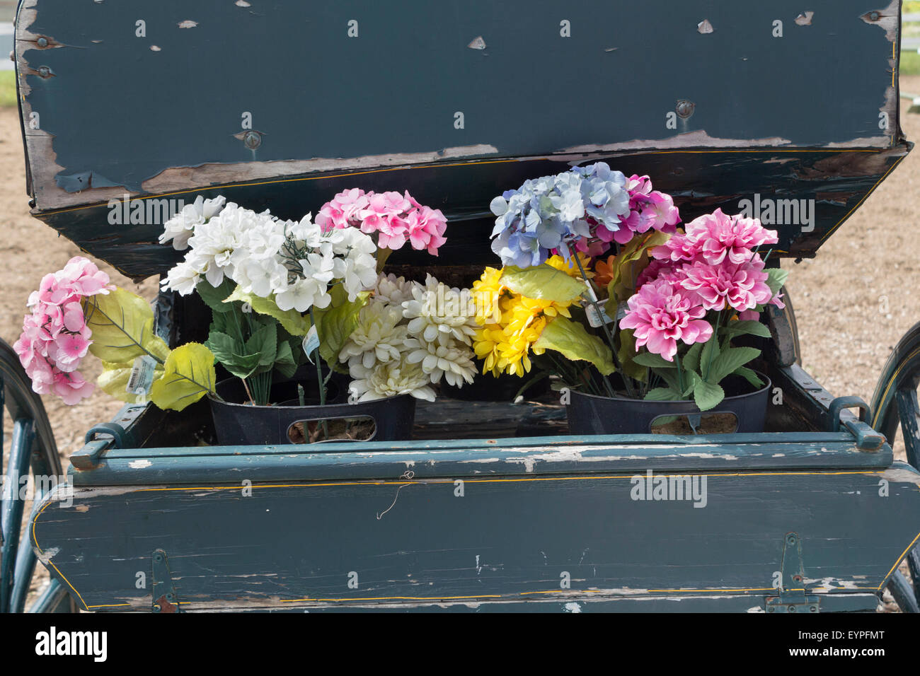 Künstliche Blumen schmücken die Rückseite einer alten antiken Kutsche Stockfoto