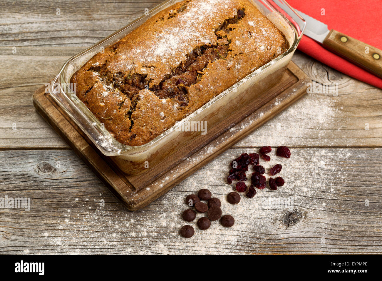 Frisch gebackene hausgemachte Zucchini Brot im Glas-Pfanne mit Messer und Tuch Serviette auf rustikalen Holz. Stockfoto