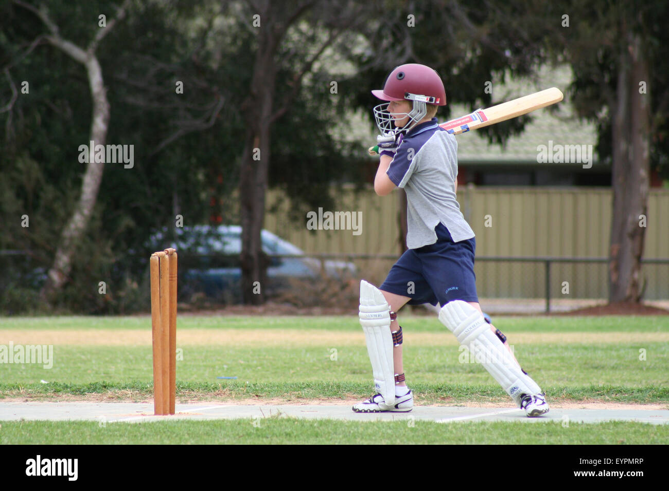 Einen jungen Cricket-Spieler nach den Ball bei einem Nachwuchsspiel Cricket in einem Vorort von Adelaide, South Australia Stockfoto