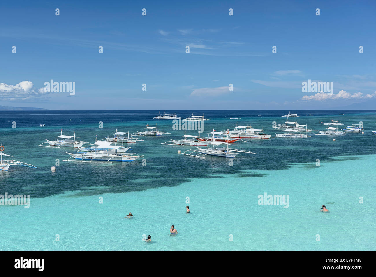 Bohol, Philippinen - 1. Juni 2015: Schwimmer und Banca Boote am Alona Beach auf Panglao Island, Bohol. Stockfoto
