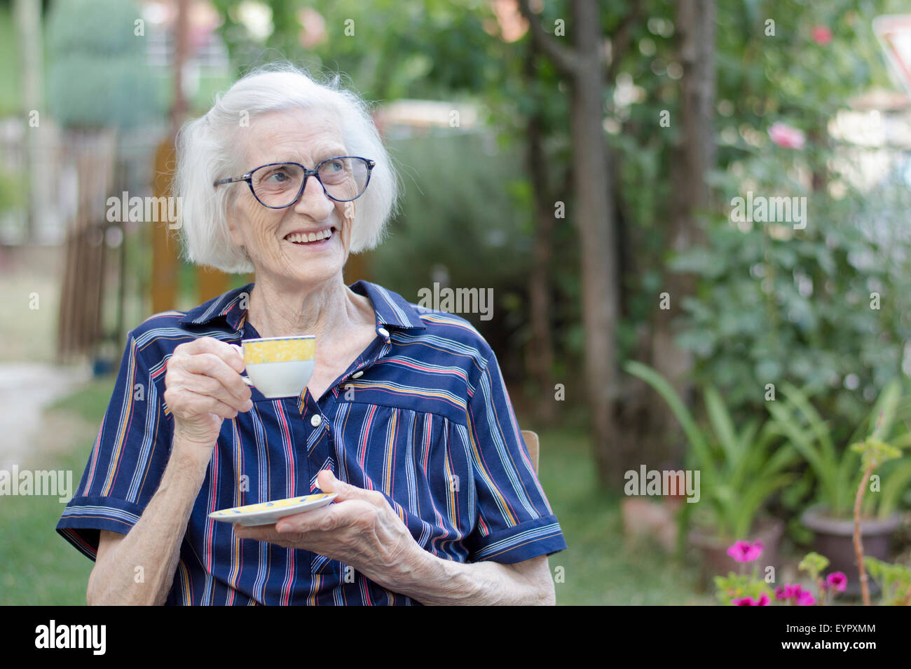 Alte Oma mit Tasse Kaffee im freien Stockfoto
