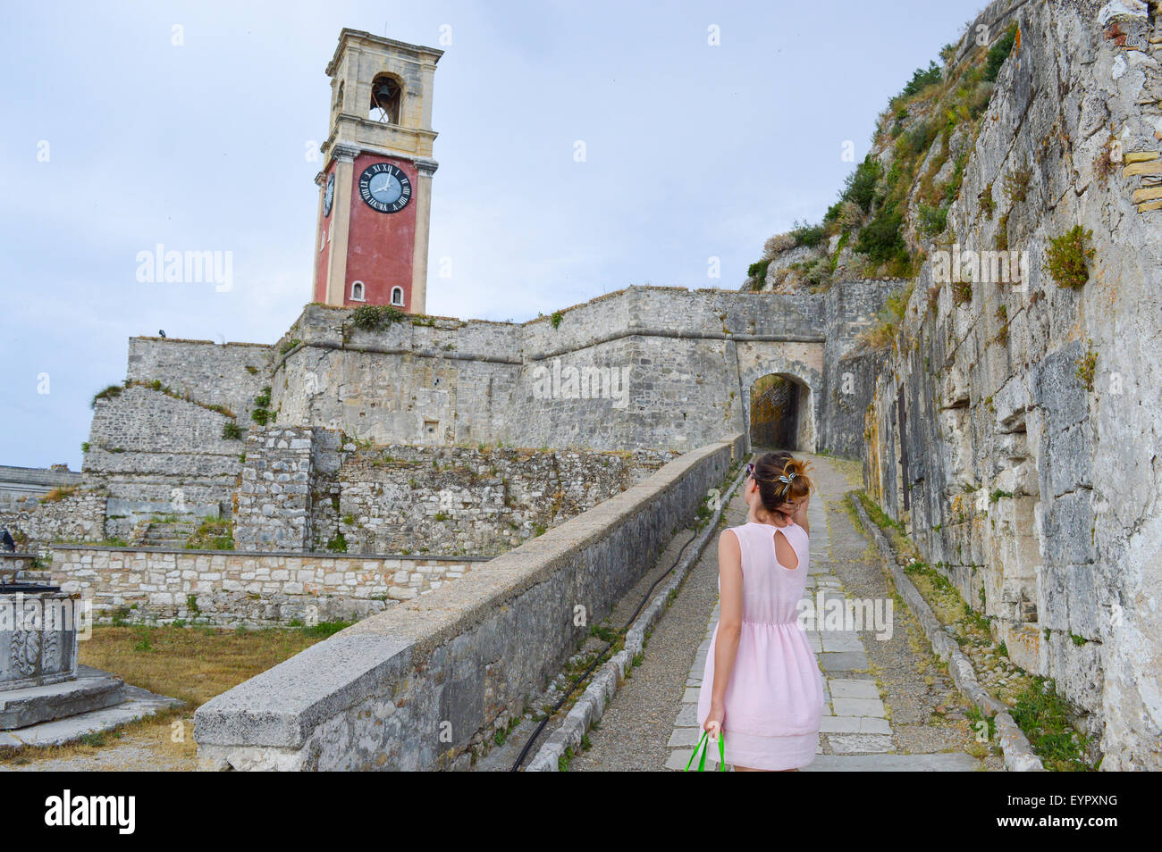 Mädchen auf der Suche auf die großen alten Uhr in eine neue Festung auf der Insel Korfu Stockfoto