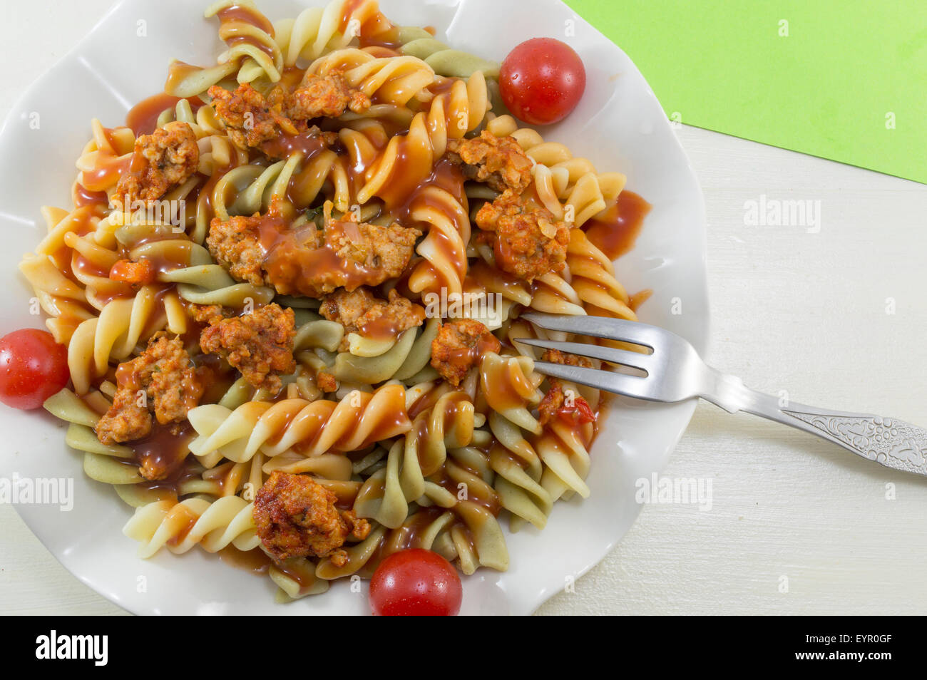Bunte Nudeln mit Fleisch und Tomaten serviert Stockfoto