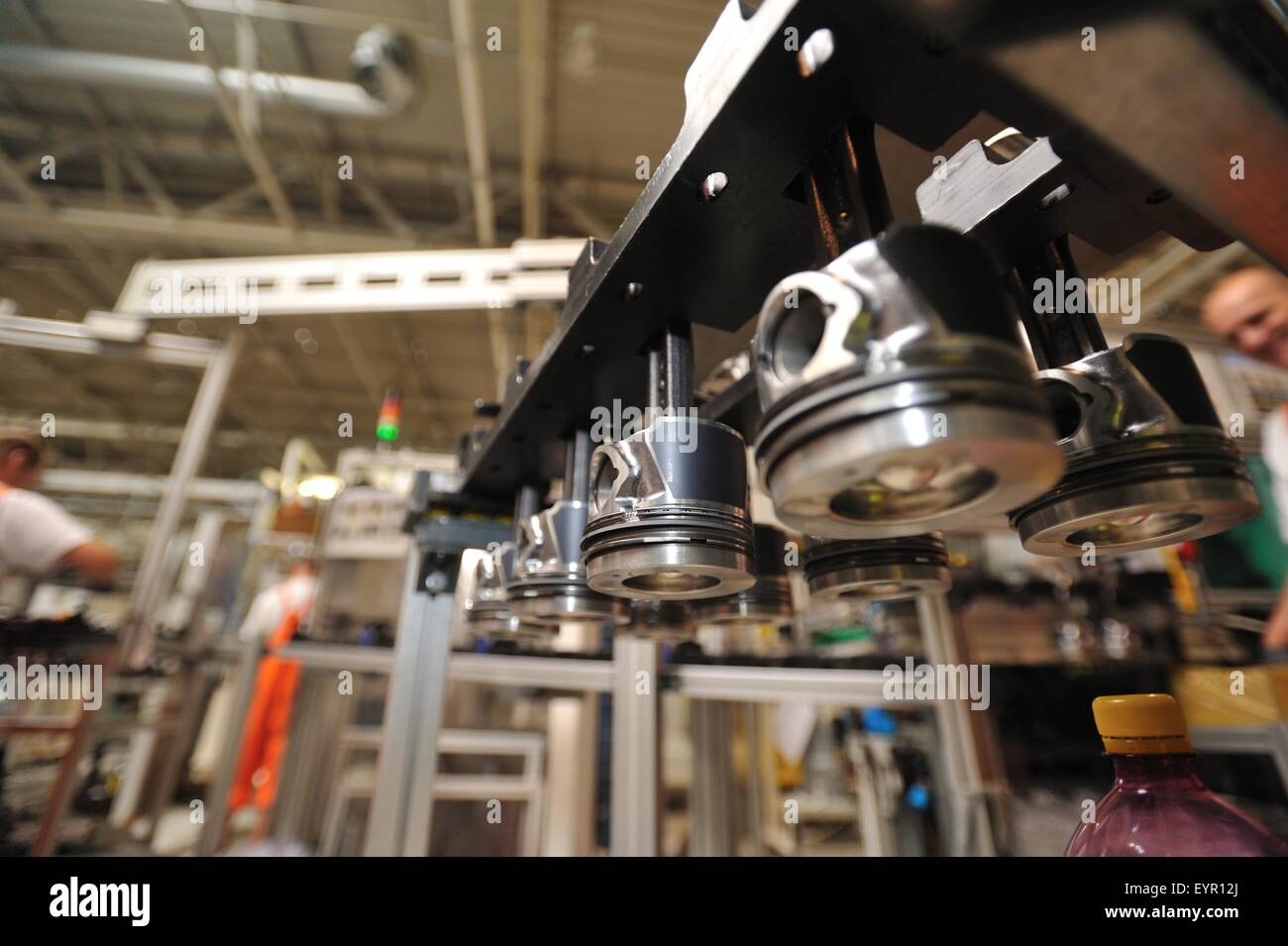 In einer modernen Automobilfabrik bewegen Fahrzeuge und Ersatzteile durch den Produktionsprozess Kolben bereit, die in Motoren eingebaut werden Stockfoto
