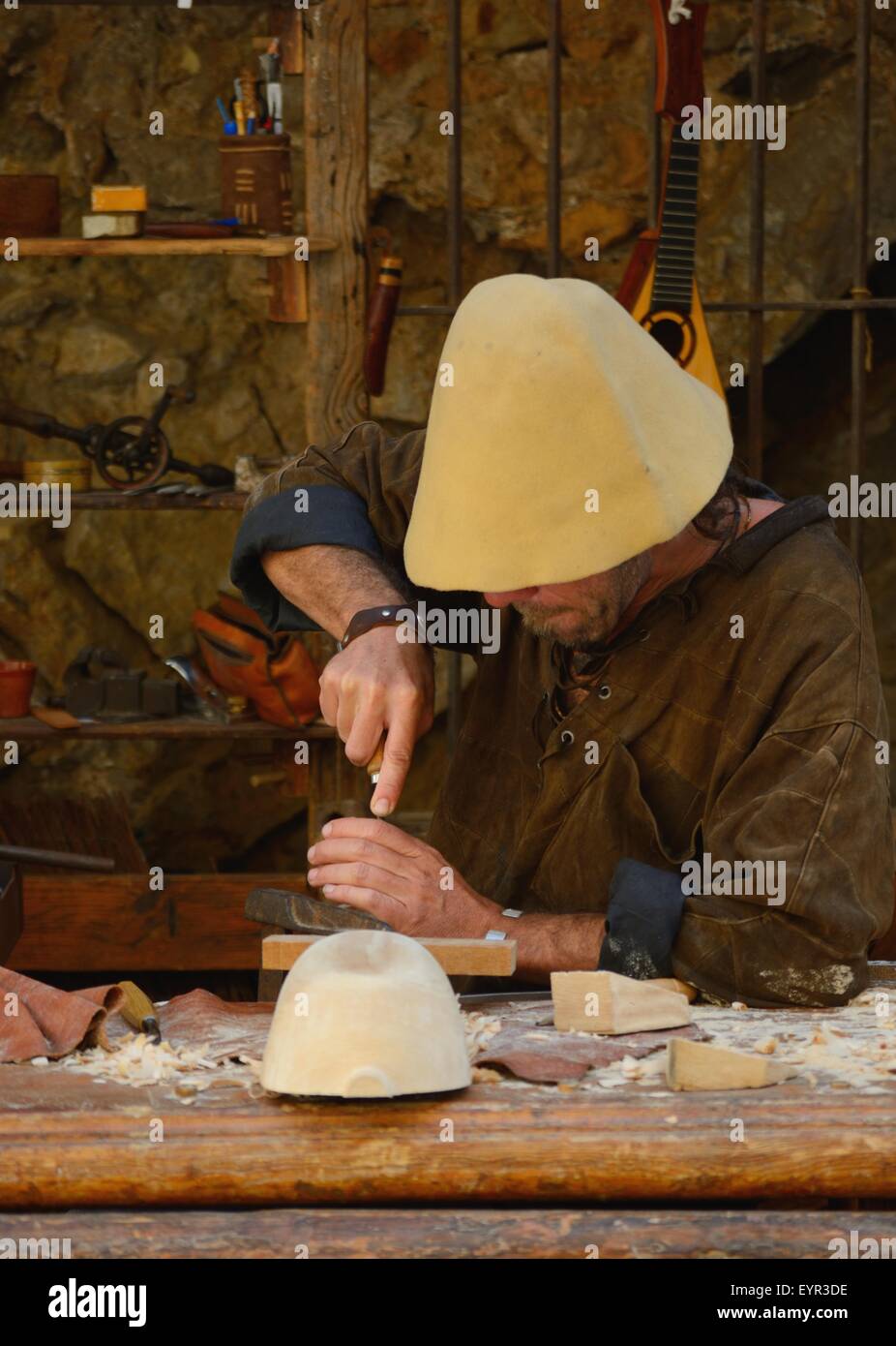 Zimmermann im Stil eines mittelalterlichen Holzschnitzers, der auf einer Straßenmesse in der Altstadt von Ibiza, Spanien, Laute macht Stockfoto