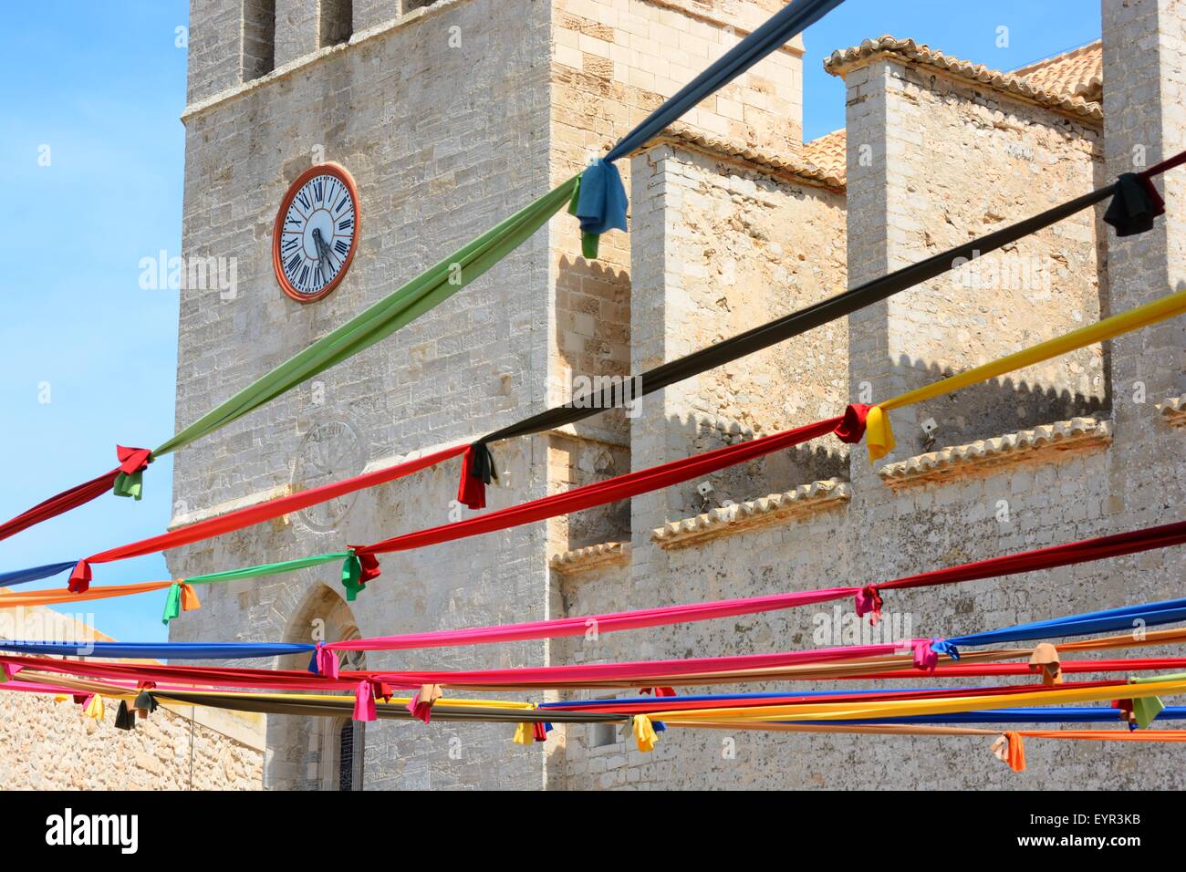 Mittelalterlicher Innenhof der Altstadt von Ibiza-Kirche, Karnevalsbänder hängen über dem Platz Stockfoto