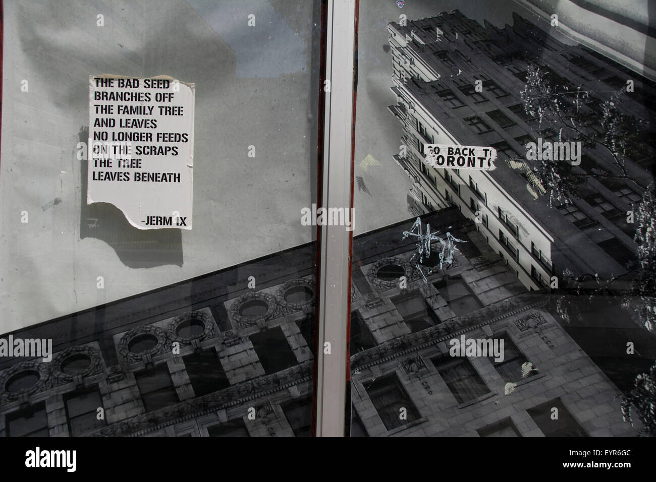 Ein Poster und Aufkleber im Fenster eines stillgeschehenden Ladens. Es sorgt für ein sehr surreales Bild. King Street East, Hamilton, Ontario. Stockfoto
