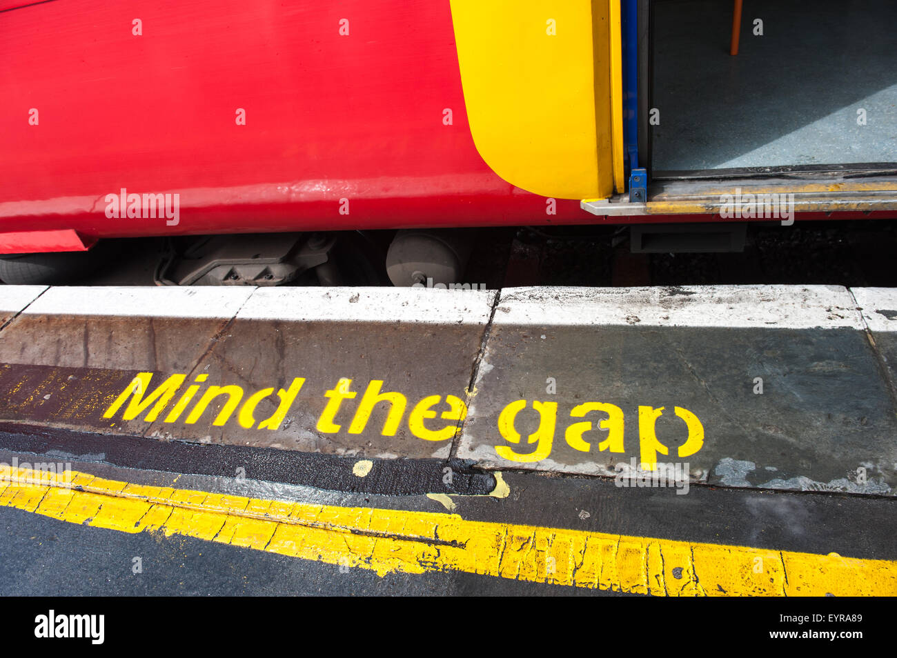 London England. Bunte Süd-West-Zug und Plattform mit "dagegen die Lücke" in gelb. Stockfoto