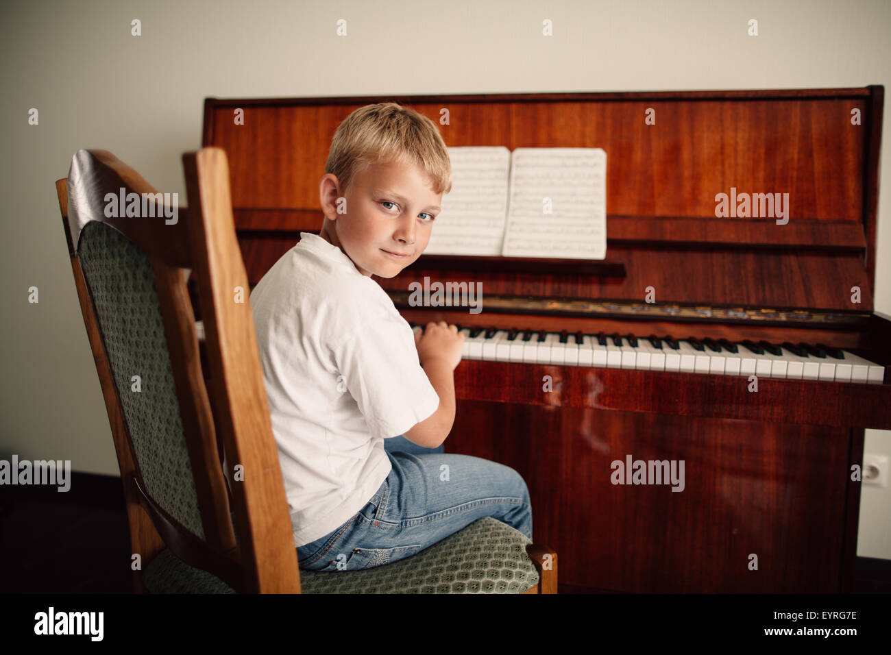 wenig fröhlicher Junge spielt Klavier Stockfoto