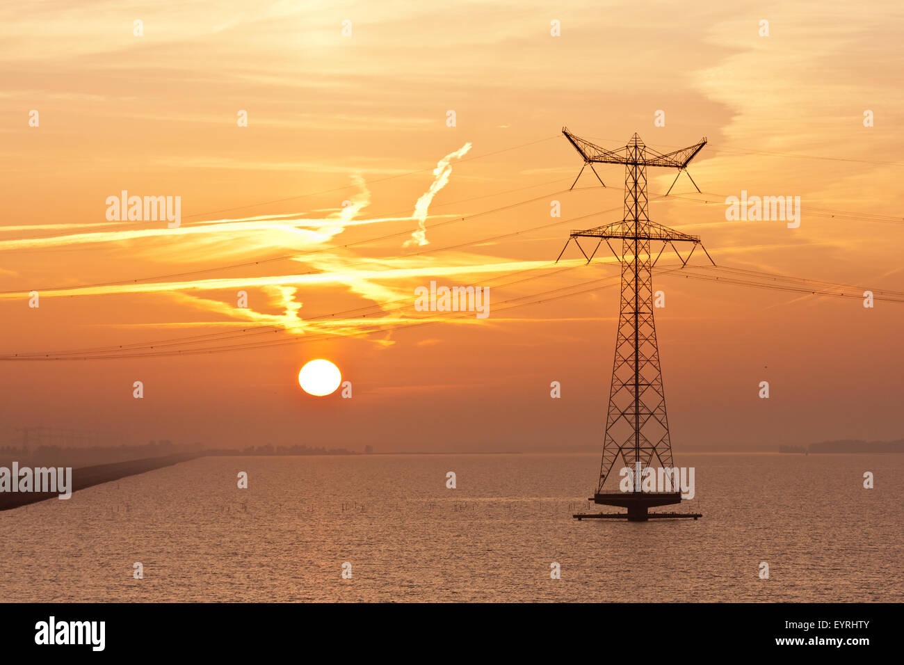 Sonnenaufgang über dem niederländischen Meer mit der Silhouette einer Strom-pylon Stockfoto