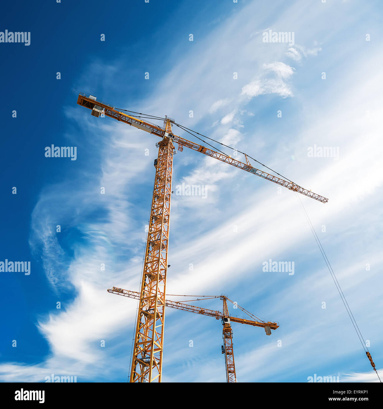 Krane auf Baustelle gegen blauen Himmel, quadratische Format Stockfoto