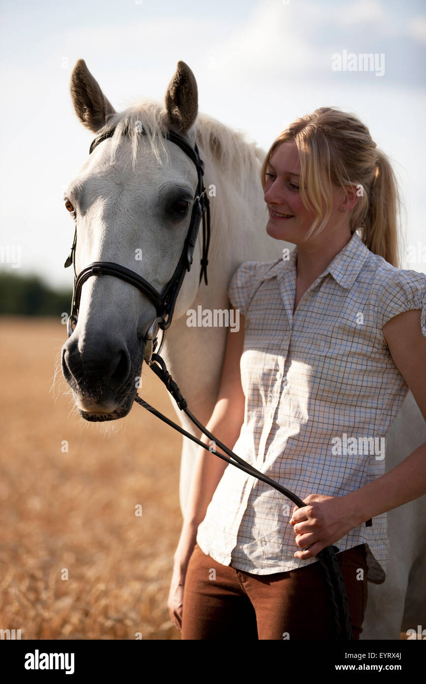 Eine junge Frau mit einem Pferd in einem Weizenfeld Stockfoto