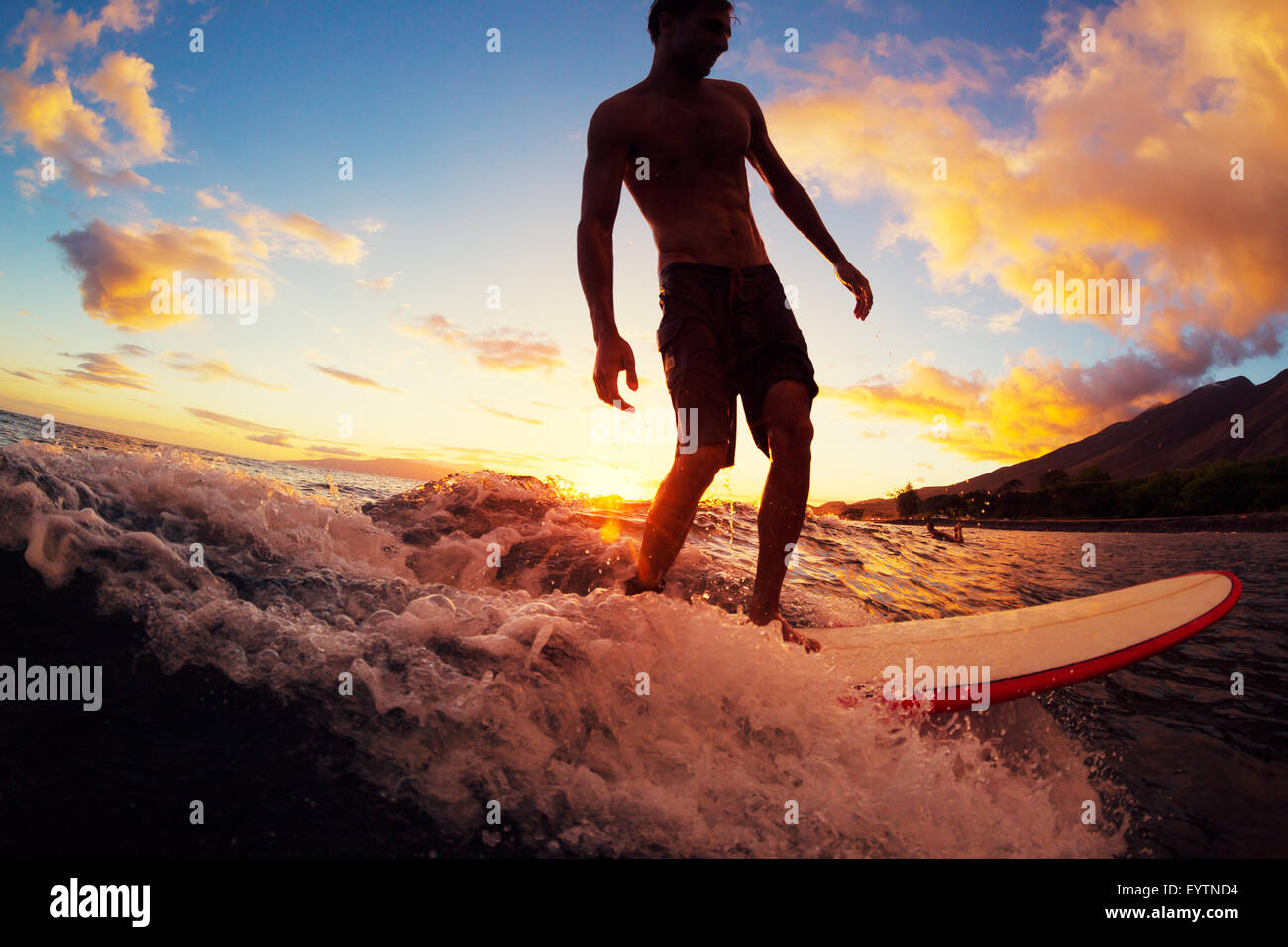 Surfen bei Sonnenuntergang. Junger Mann auf Welle bei Sonnenuntergang. Outdoor-aktiven Lebensstil. Stockfoto