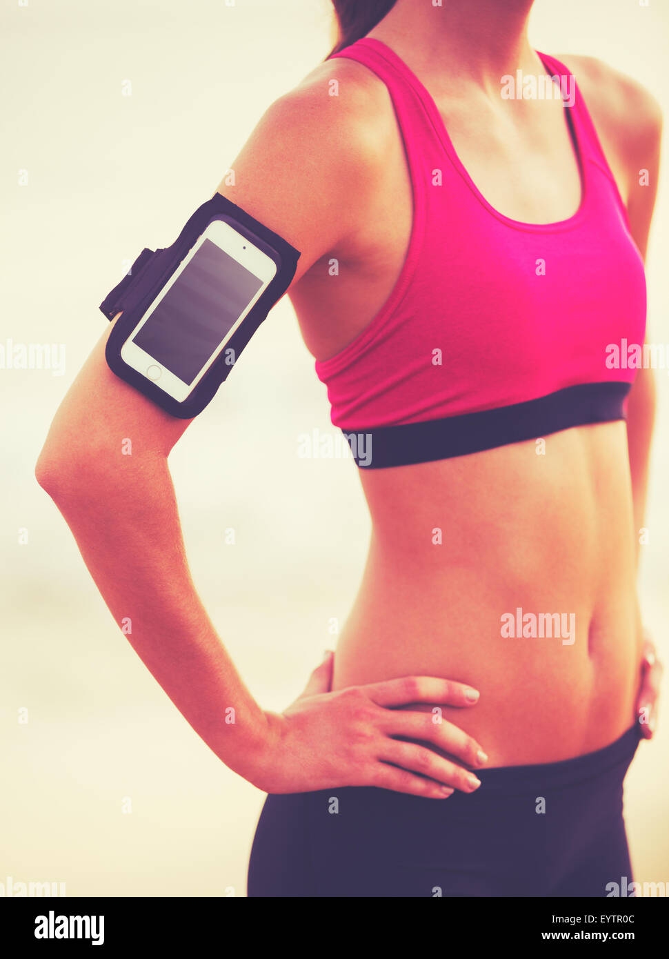 Aktiv gesund Sport Lifestyle mit moderner Technik. Junge attraktive Fitness-Frau mit Ihrem Smartphone bereit für Training. Stockfoto