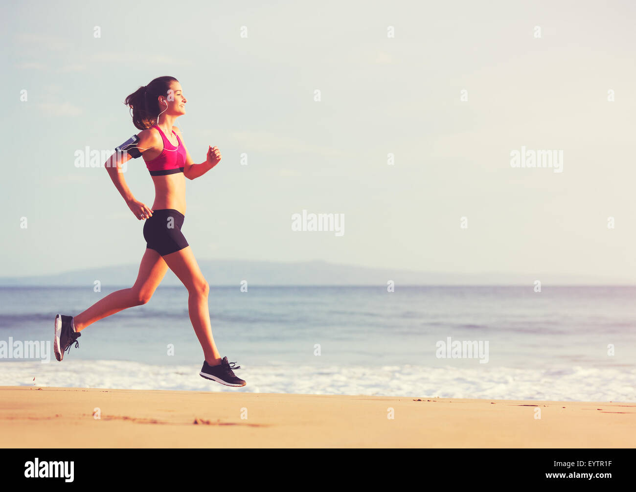 Gesunden, aktiven Lebensstil. Junge Sport Fitness Frau laufen am Strand bei Sonnenuntergang. Stockfoto