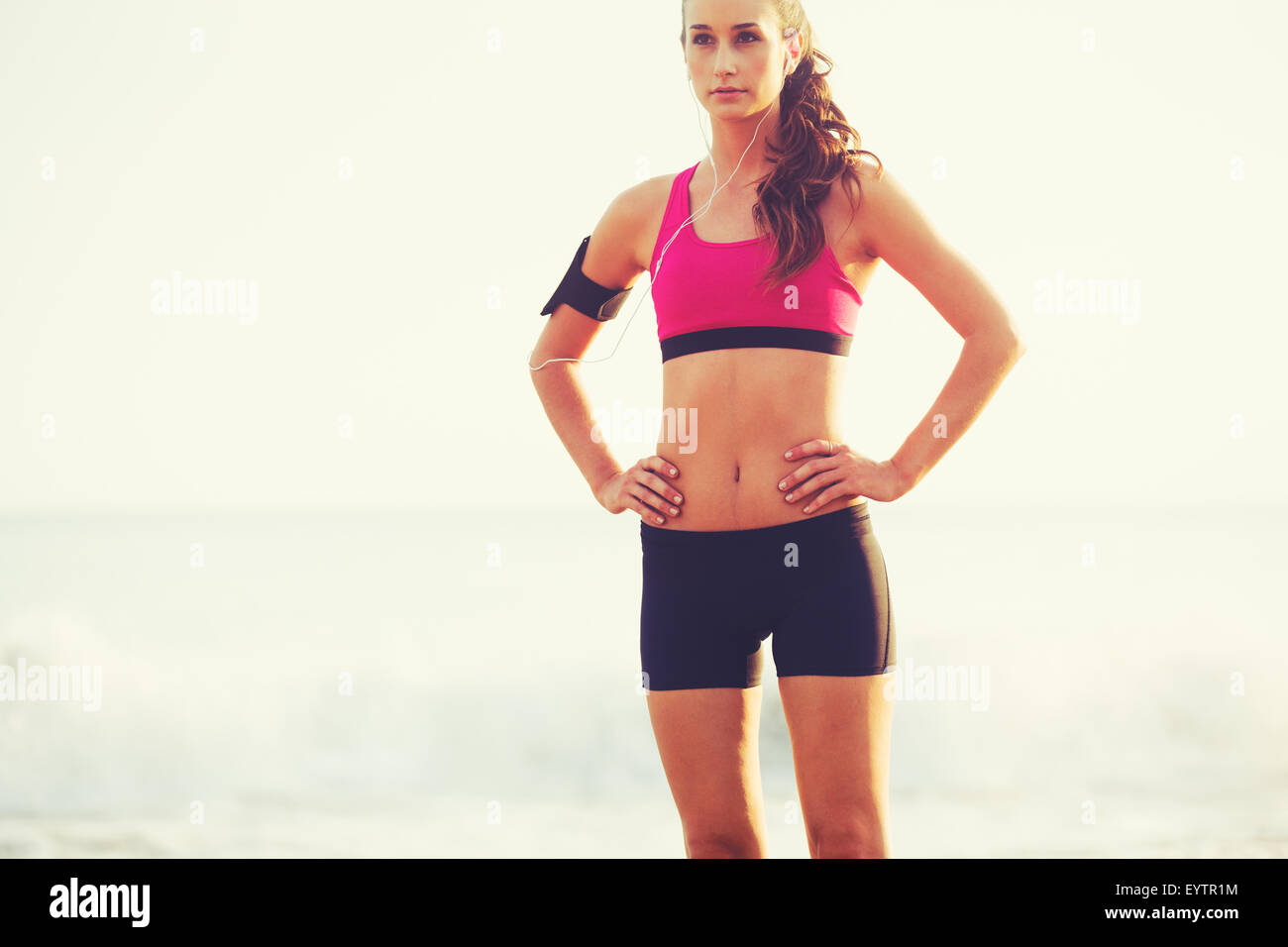 Gesunden, aktiven Lebensstil. Young Sport Fitness-Frau am Strand bei Sonnenuntergang bereit für Training. Stockfoto