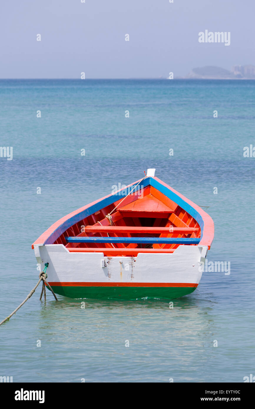 Einzelne rote und weiße Holz Fischerboot allein in der Bucht von Pampatar Beach, Insel Margarita. Venezuela Stockfoto