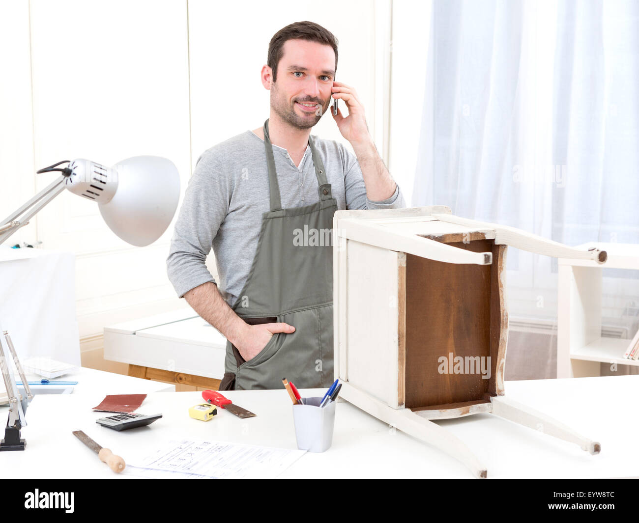 Blick auf eine junge attraktive Zimmermann arbeitet in seiner Werkstatt Stockfoto