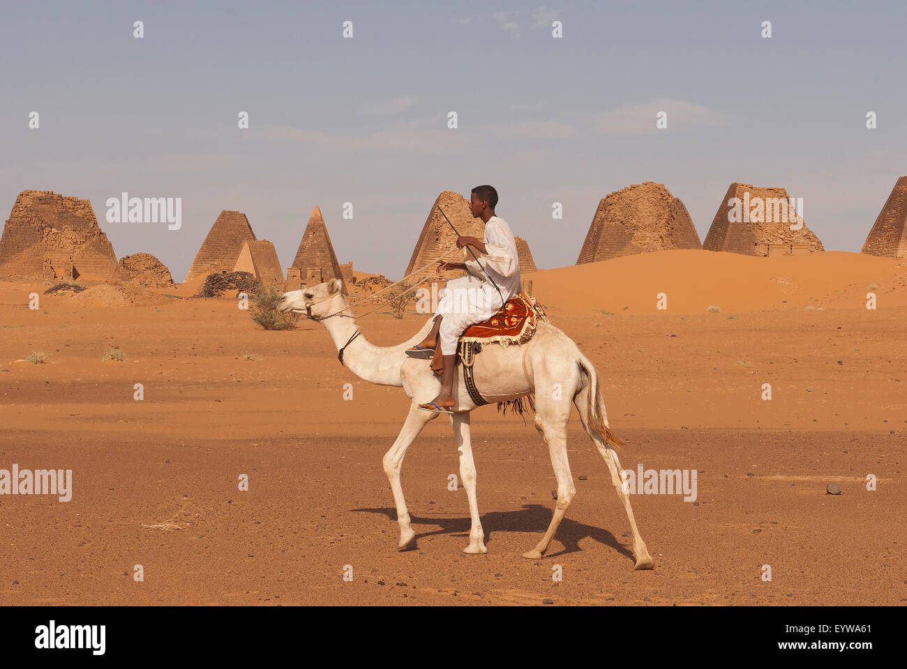 Lokale Mann reitet ein Dromedar vor den Pyramiden von den Norden Friedhof von Meroe, Nubische Wüste, Nubia, Nahr an-Nil, Sudan Stockfoto