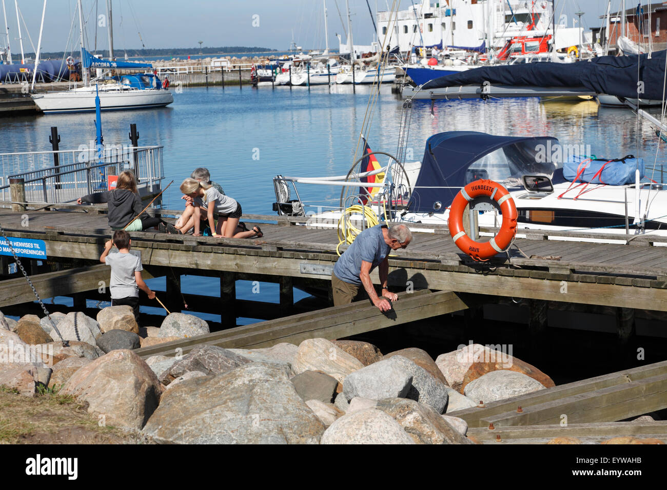 Touristenfamilie auf Segelurlaub Genießen Sie morgendliche Aktivitäten und gemütliches Ambiente im Hundested Harbour, Zealand, Dänemark. Dänische Hygge. Steg, Brücke. Stockfoto
