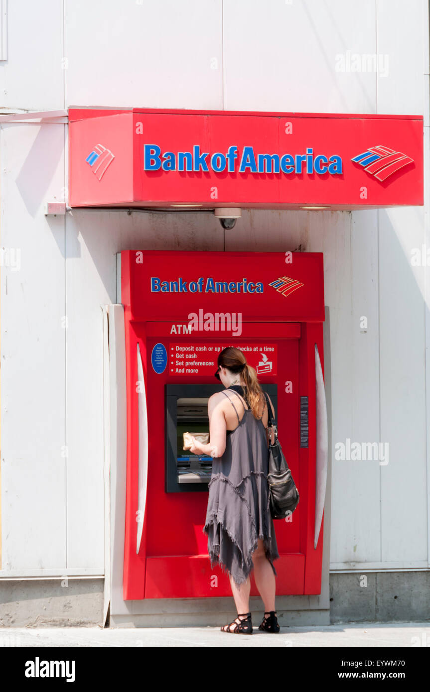 Frau mit einem Geldautomaten in der Wand einer Bank von Amerika Bank in Seattle. Stockfoto