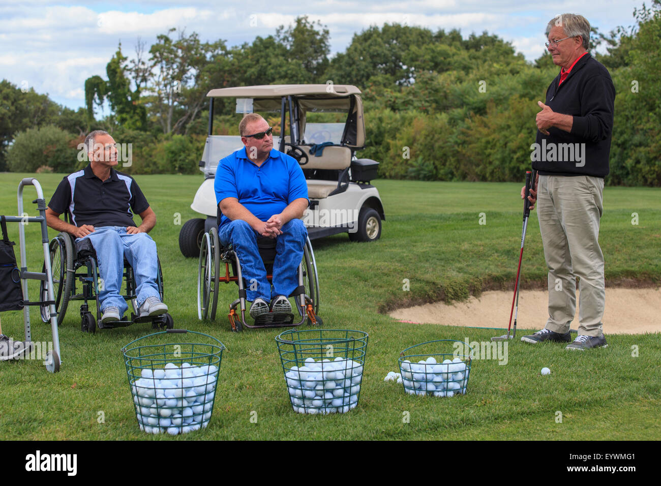 Zwei Männer im Rollstuhl mit Verletzungen des Rückenmarks Golf von einem Lehrer lernen Stockfoto