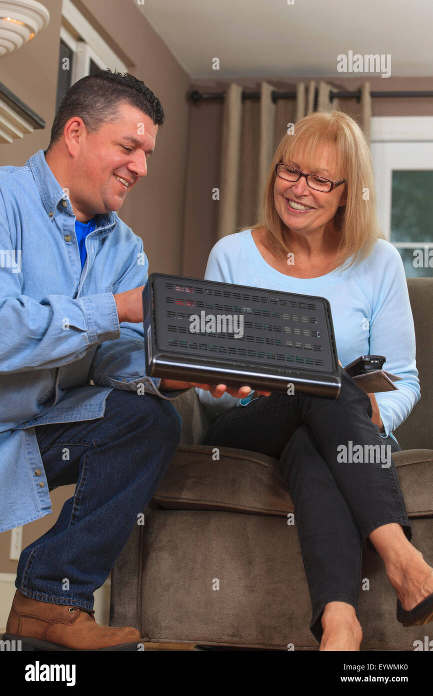 Service-Mann zeigt Hausbesitzer wie mithilfe die Kabelbox Stockfoto