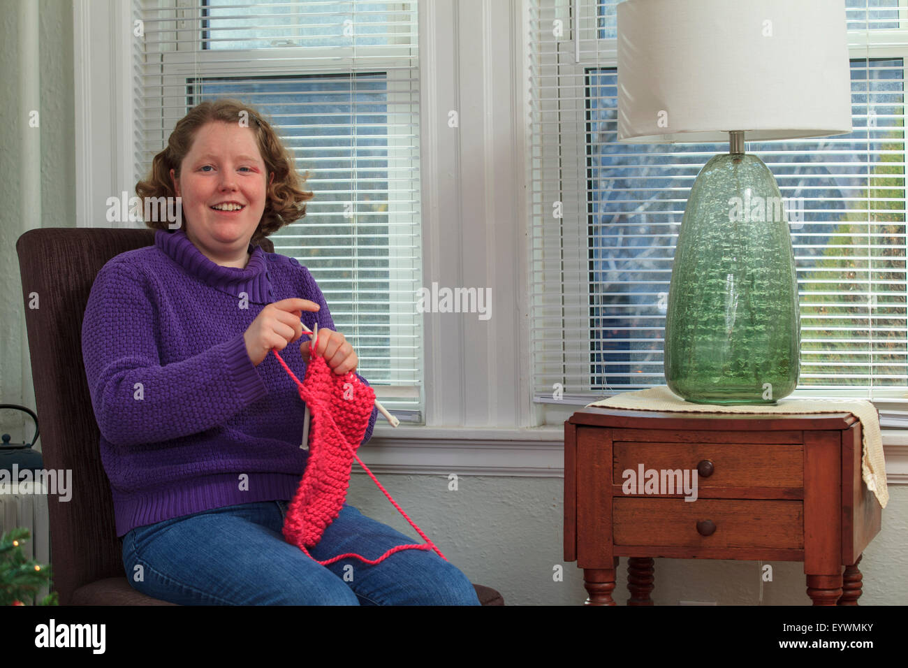 Junge Frau mit Autismus stricken für die Feiertage Stockfoto