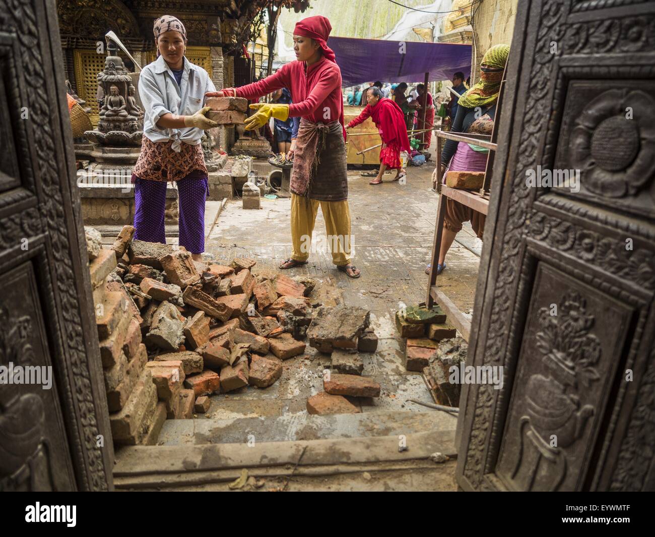 31. Juli 2015 - Kathmandu, Nepal - Arbeiter Ziegel von Swayambhunath, auch bekannt als die Affentempel zu erholen. Es ist ein Komplex von buddhistischen und hinduistischen Tempel in Kathmandu. Es wurde in Nepal Erdbeben stark beschädigt. Das Erdbeben in Nepal am 25. April 2015, (auch bekannt als der Gorkha Erdbeben) mehr als 9.000 Menschen getötet und verletzt mehr als 23.000. Es hatte eine Stärke von 7,8. Das Epizentrum lag östlich der Stadtteil Lamjung, und seine Hypozentrum lag in einer Tiefe von ca. 15Â Kilometer (9.3Â Meile). Es war die schlimmste Naturkatastrophe seit 1934 Nepal Nepal Streikrecht '' "Bihar Erdbeben. Der ea Stockfoto