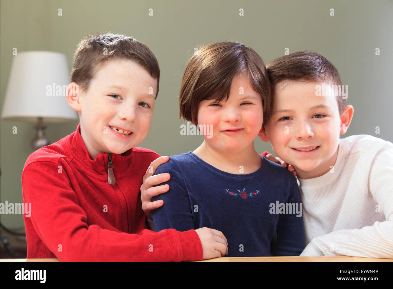 Kleines Mädchen mit Down-Syndrom, spielen mit ihren Brüdern Stockfoto
