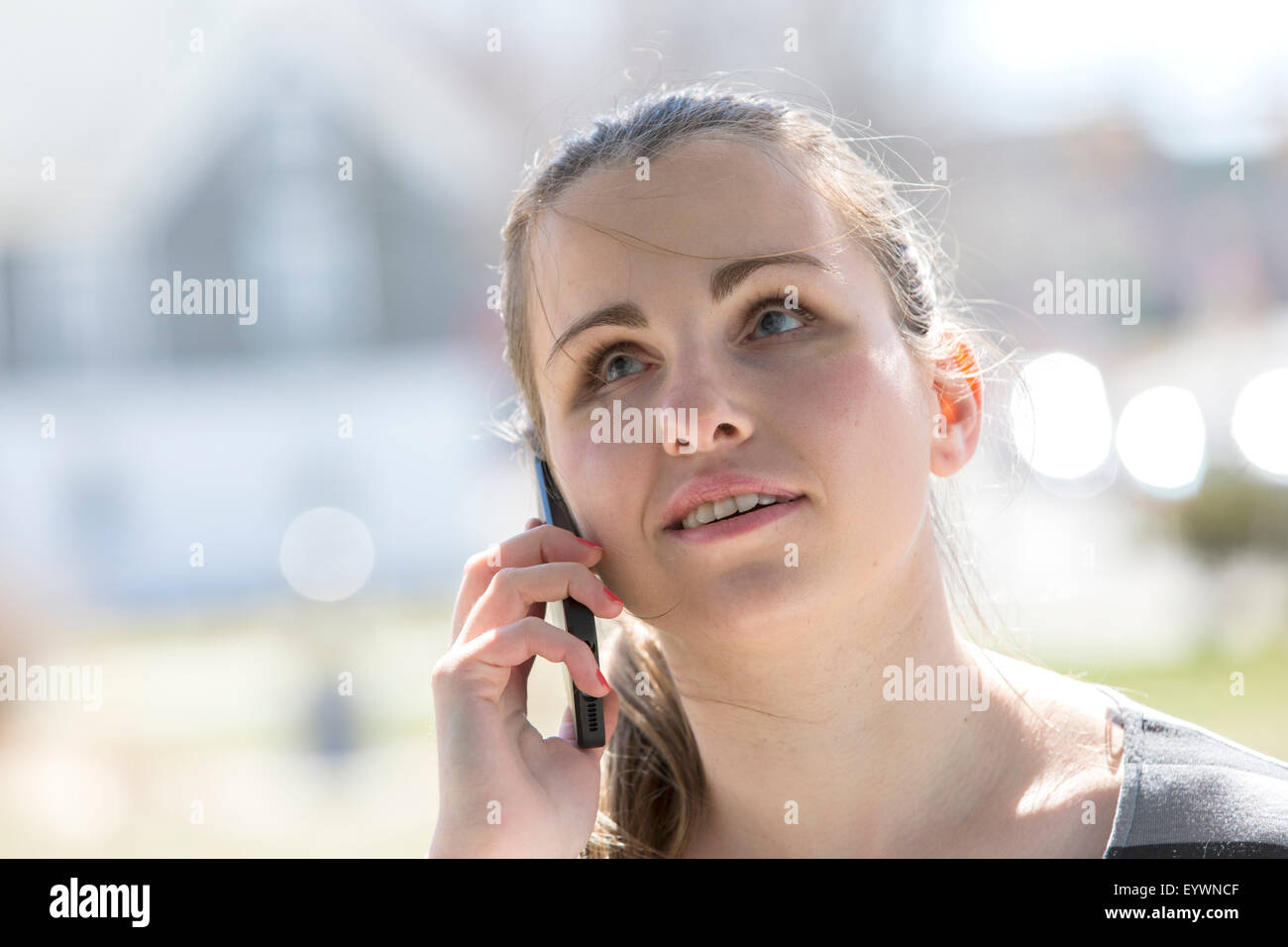 Blinde junge Frau reden über ihr Handy Stockfoto
