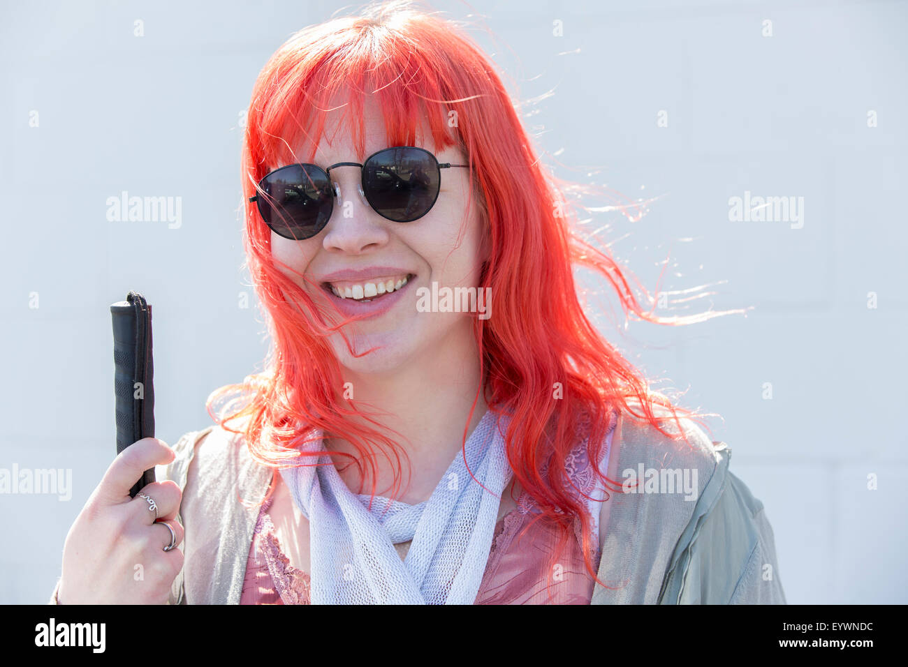 Junge blinde Frau lächelnd mit ihrem Rohrstock Stockfoto