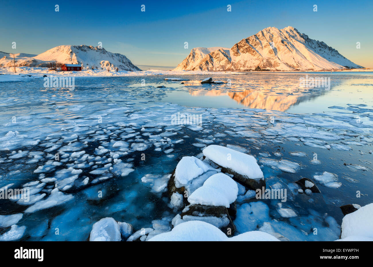 Berge von Gymsoya (Gimsoya) aus Smorten spiegelt sich im kristallklaren teilweise gefrorenen Meer, Lofoten Inseln, Arktis, Norwegen Stockfoto