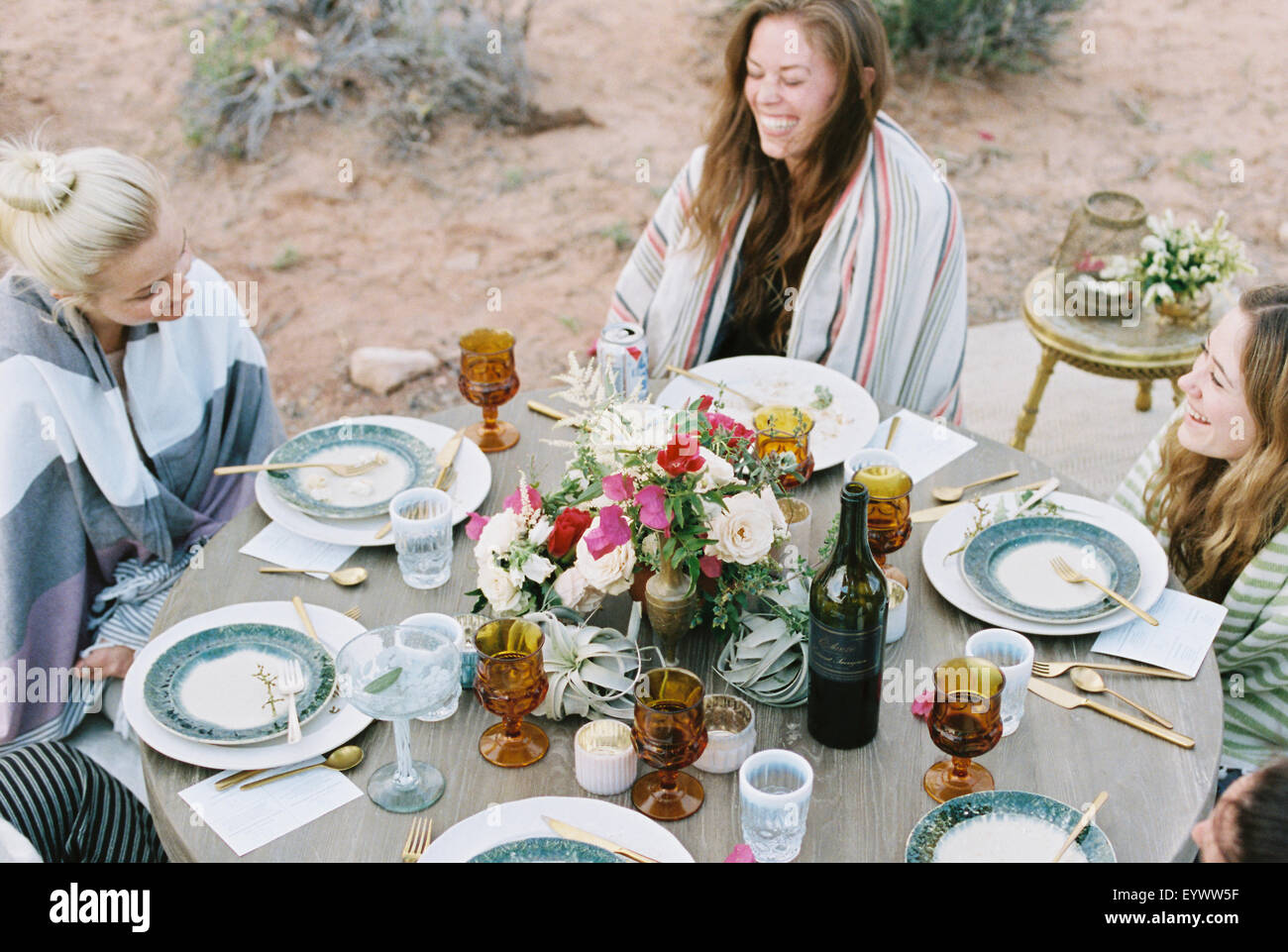 Eine kleine Gruppe von Frauen genießen eine Mahlzeit im Freien, in einer Wüste. Stockfoto