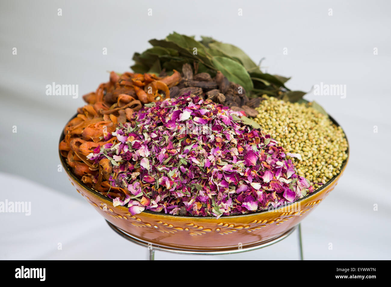 Eine Schüssel mit Gewürzen und Kräutern, die in der indischen Küche einschließlich Rosenblüten, Koriandersamen, Lorbeer, Muskatblüte und schwarzer Cardamom verwendet. Stockfoto