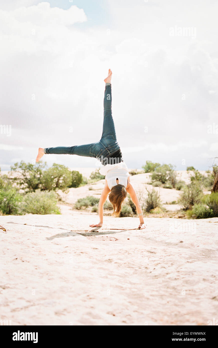 Barfuß Frau trägt Jeans, cartwheeling Stockfoto