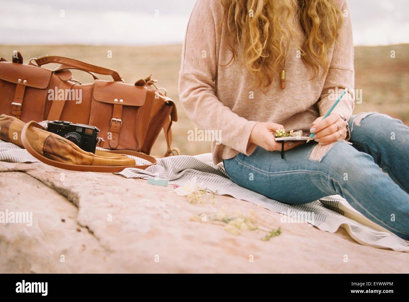 Frau mit Notebook Bleistift Leder Tasche Kamera Stockfoto