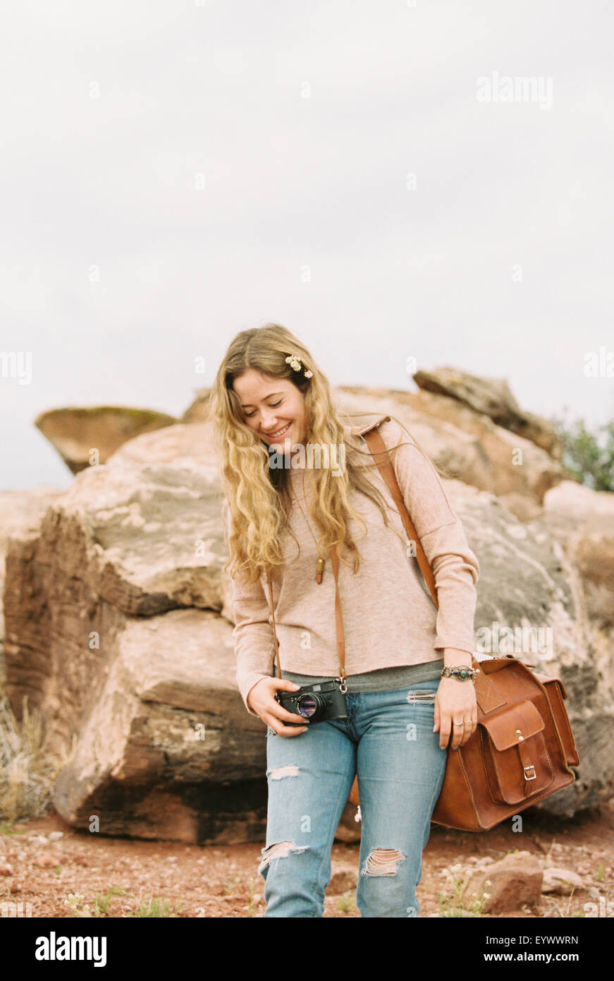 Lächelnde Frau stehend halten eine Leder Tasche. Stockfoto