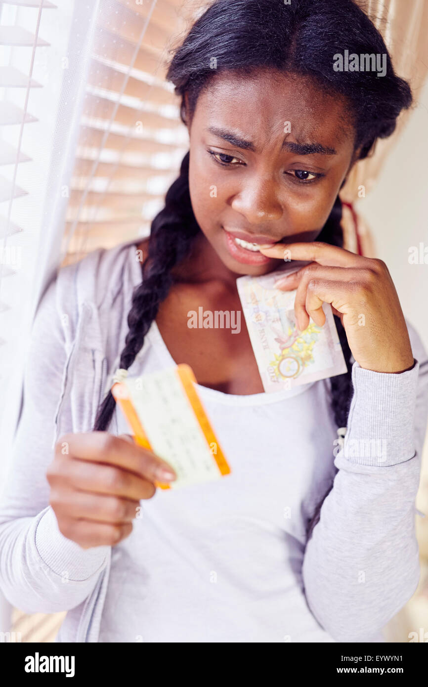 Mädchen besorgt über teure Bahntickets Stockfoto