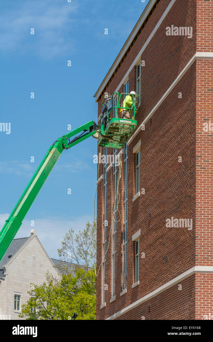 Bauarbeiter auf eine Arbeitsbühne an der Seite eines Gebäudes Stockfoto