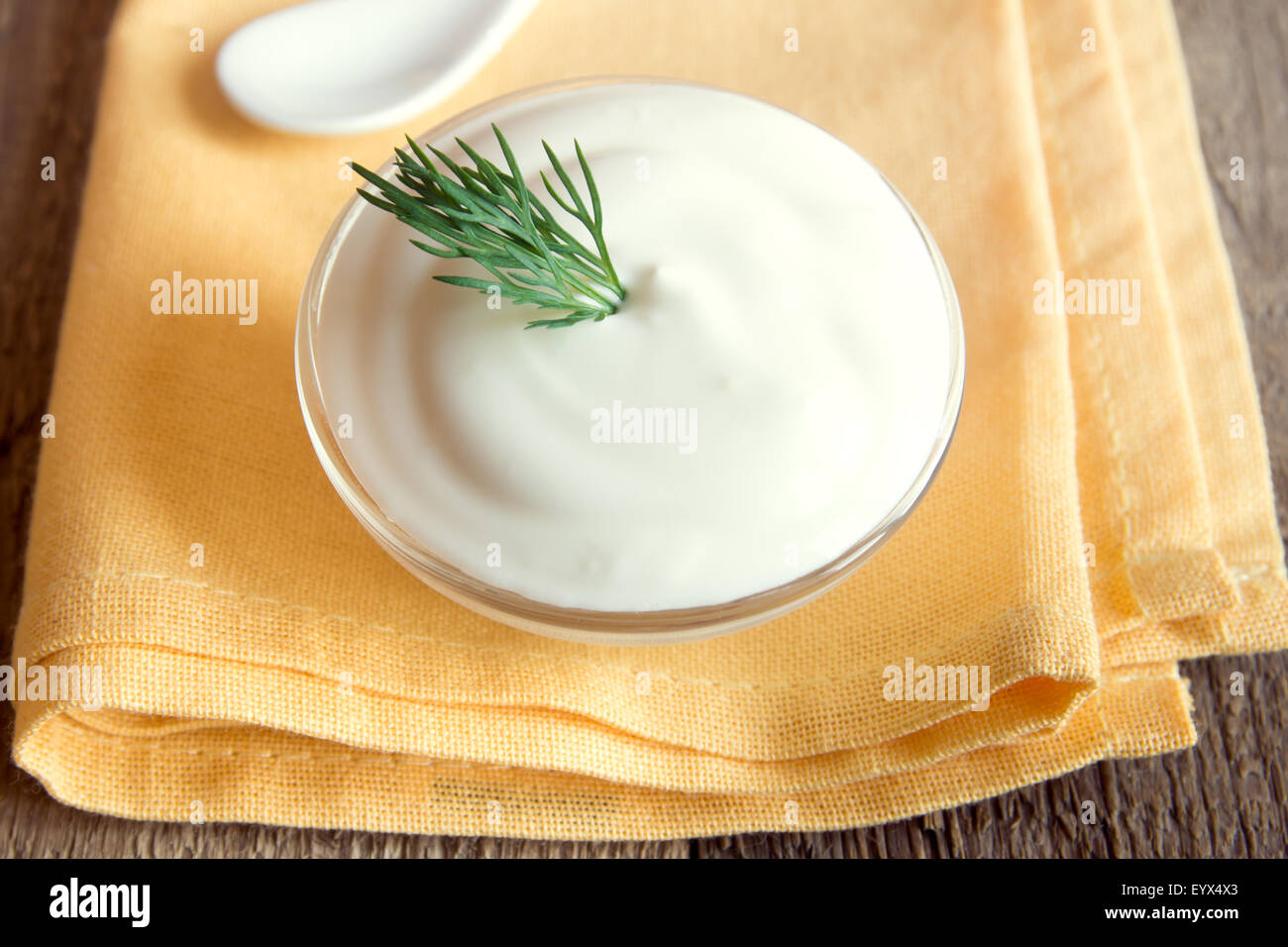 Saure Sahne (weisse Sauce) mit Dill auf Holztisch, horizontale hautnah Stockfoto