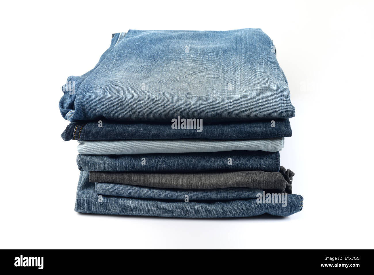 Stapel von blauen und schwarzen Jeans auf weißem Hintergrund Stockfoto