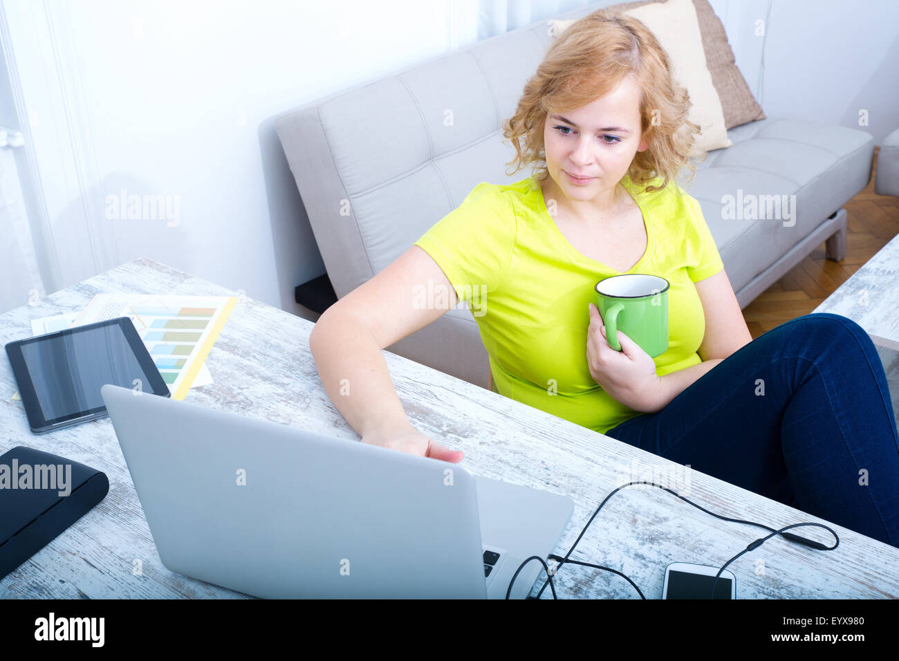 Ein plus Size Erwachsene Frau arbeitet an einem Laptop-Computer mit einer Tasse Kaffee. Stockfoto