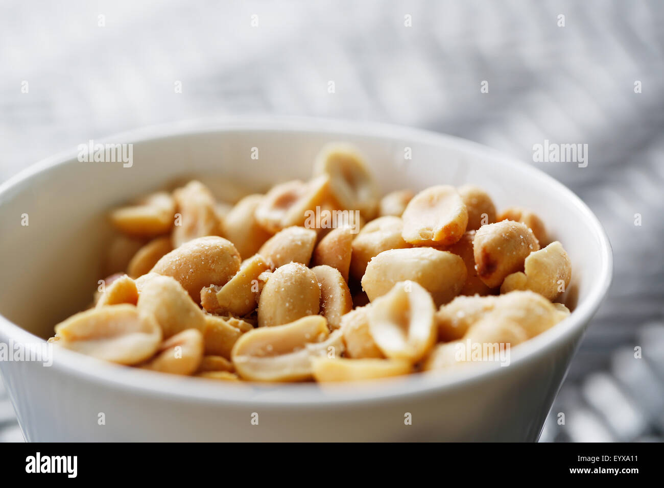 Eine kleine Schüssel mit Protein, aber Natrium-reiche Geröstete gesalzene Erdnüsse als Snack in einer kleinen weißen Schale vorgestellt. Stockfoto