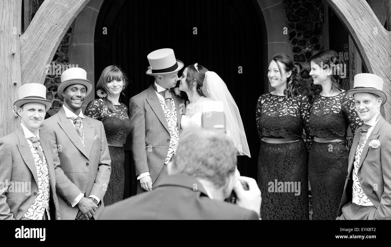 Braut und Bräutigam küssen außen Kirche Stockfoto