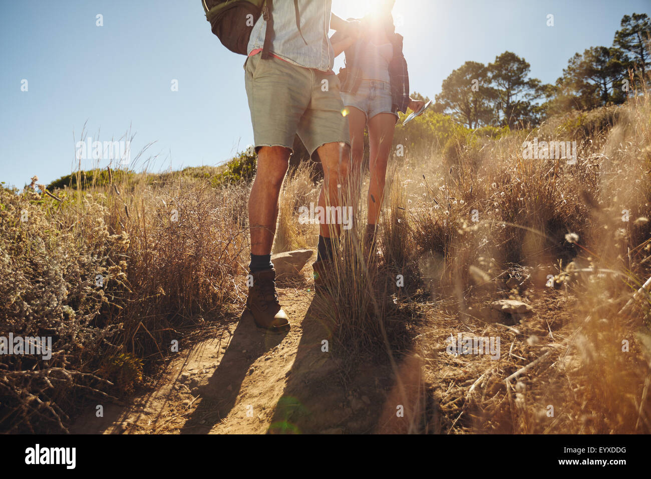 Niedrigen Winkel Ansicht von Mann und Frau Wanderer zu Fuß auf Schmutz Pfad am Berg an einem sonnigen Tag. Ein paar Wanderungen in der Natur. Stockfoto