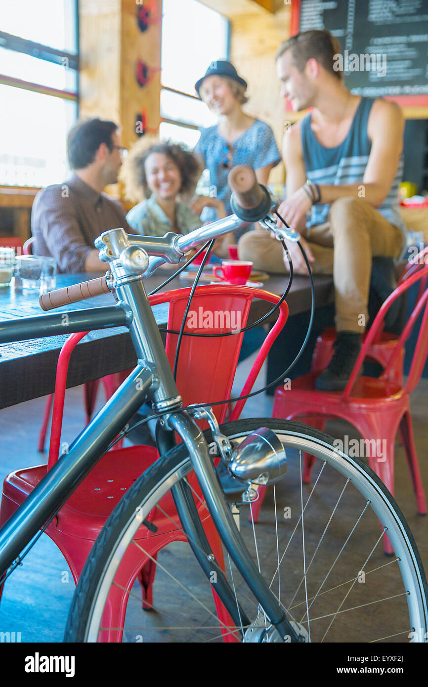 Freunde im Café hinter dem Fahrrad hängen Stockfoto