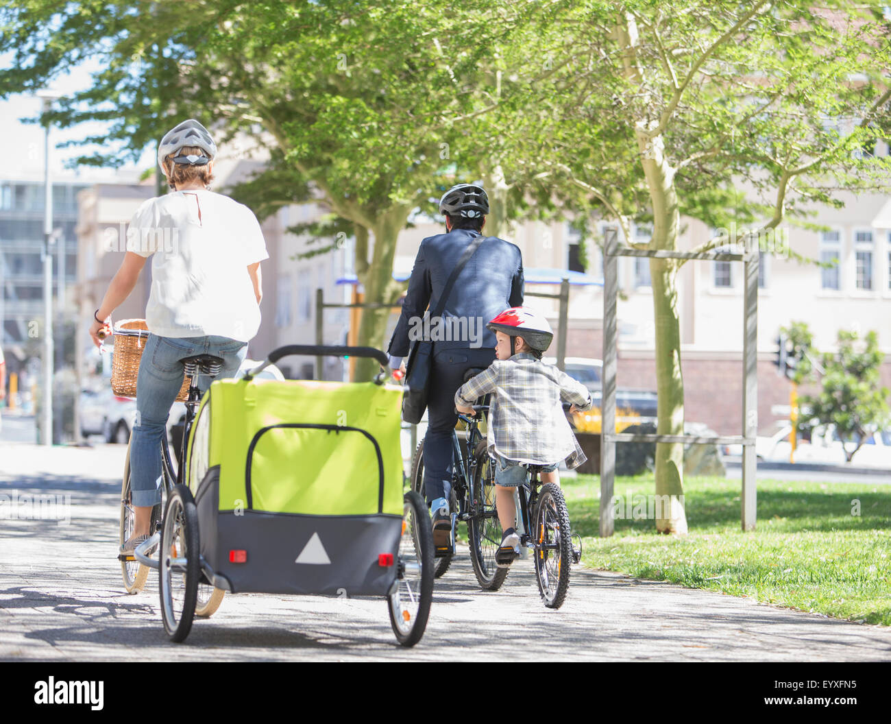 Familien, die auf Fahrrädern in sonnigen Stadtpark Stockfoto